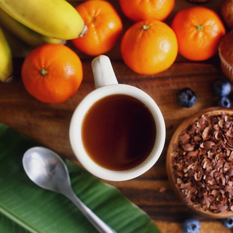 Image of a cup of cacao drink on table with mandarin oranges