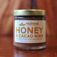 Jar of Manoa Chocolate Honey & Cacao Nibs on a wooden surface