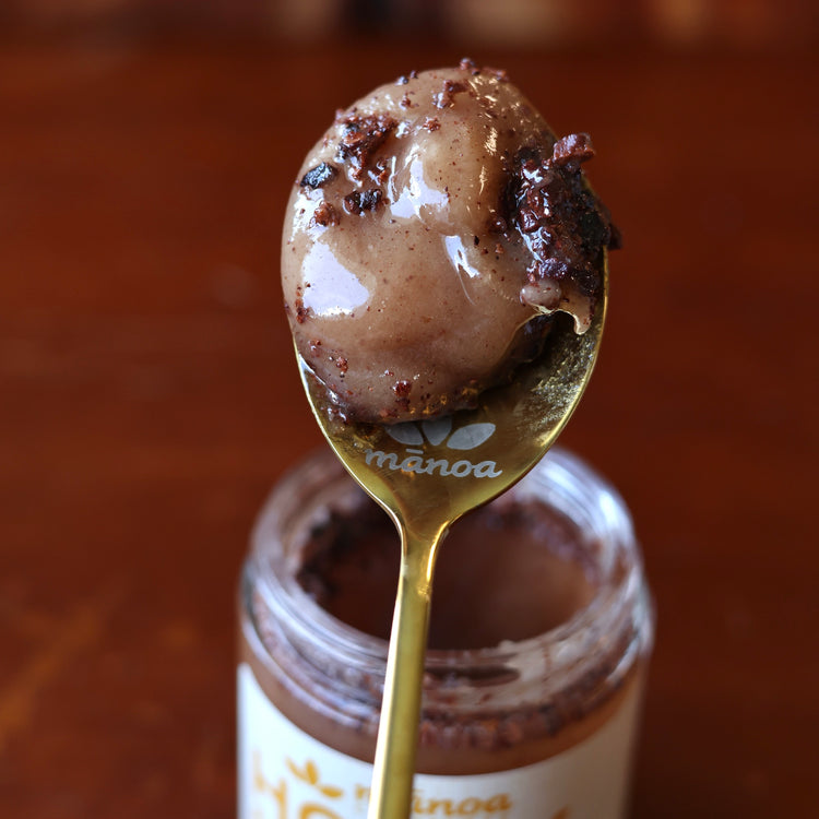 Spoonful of raw honey and nibs on a red wood background